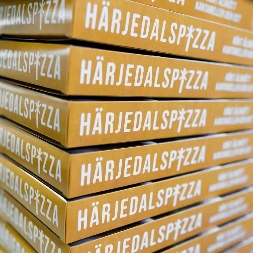 Pizzakartonger staplade på varandra med texten Härjedalspizza